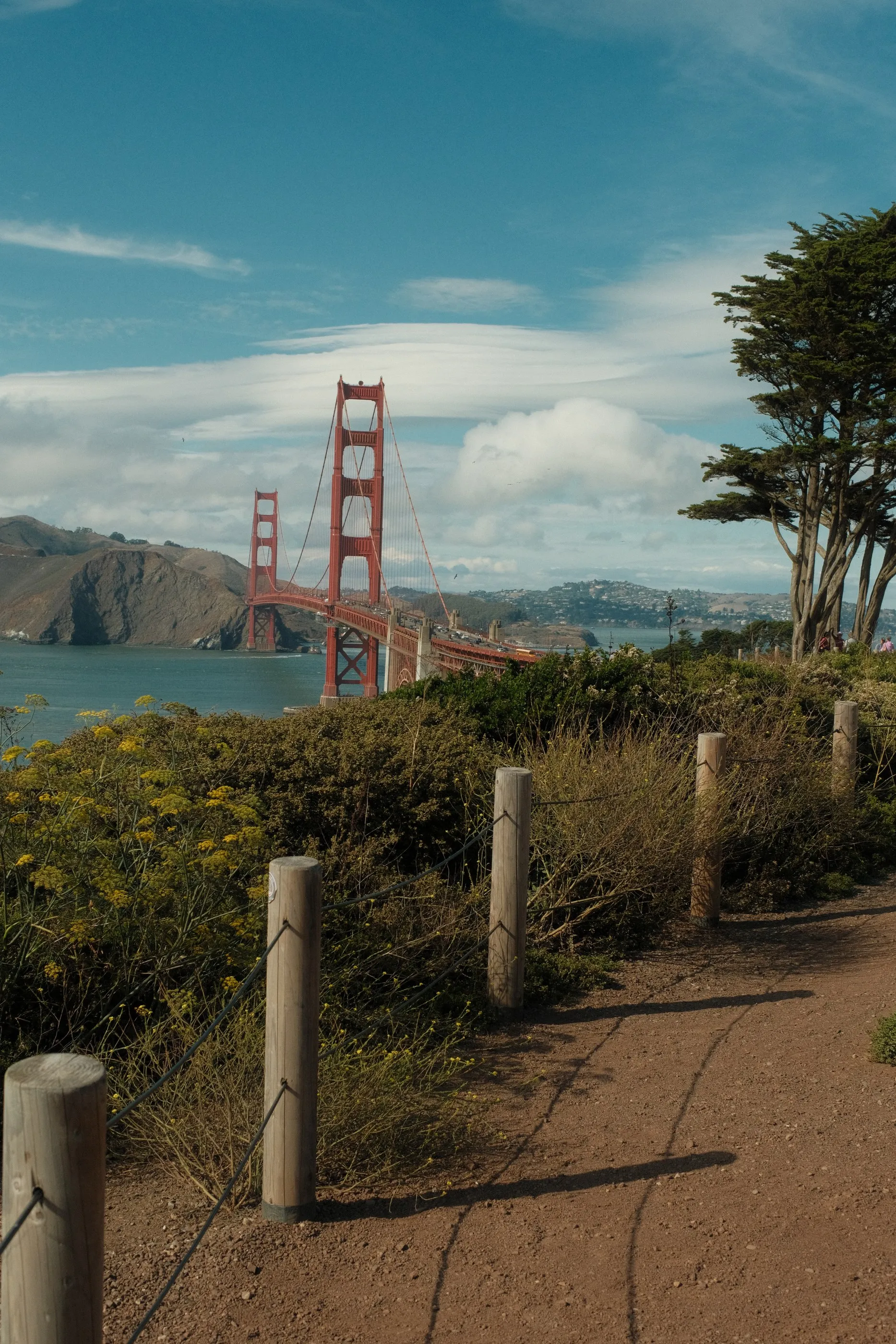 The Golden Gate Bridge in the distance beyond a sandy path