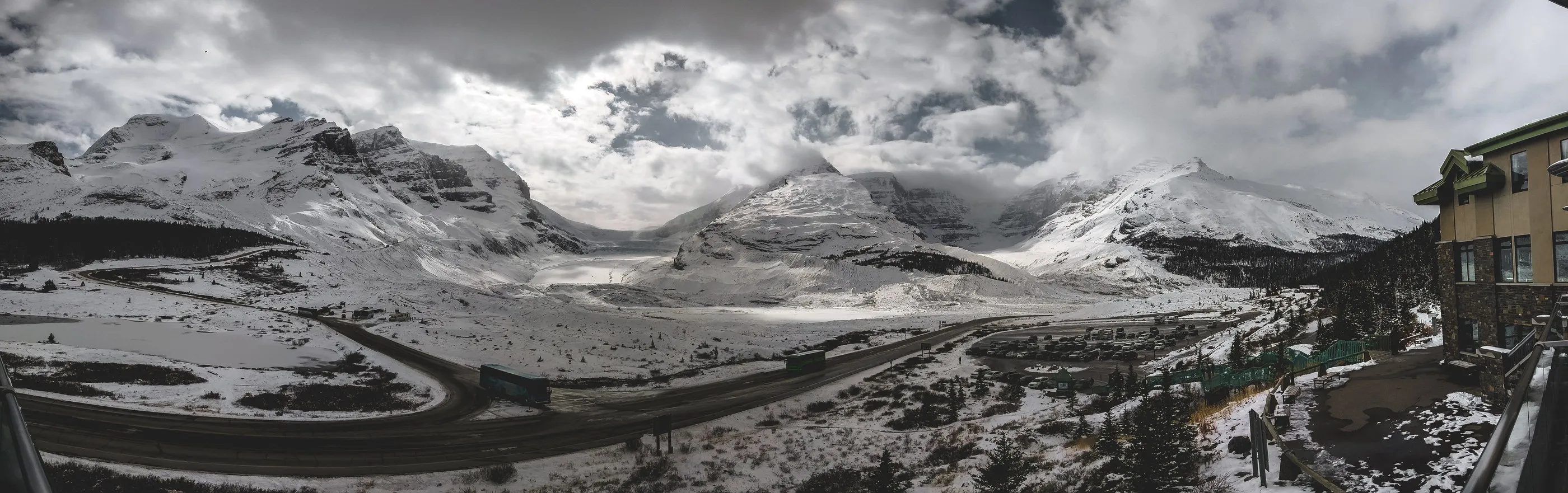 A panoramic snowy mountain landscape viewed from a lodge